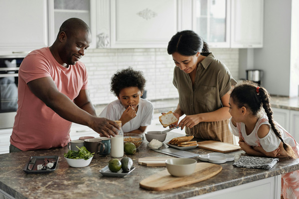 Kleine Familie zum Frühstück am Küchentisch